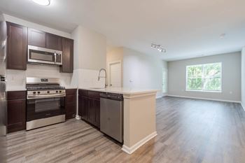 A kitchen with dark brown cabinets and stainless steel appliances.